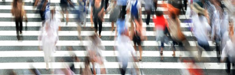 Crowd of people moving in opposite directions on a road crossing